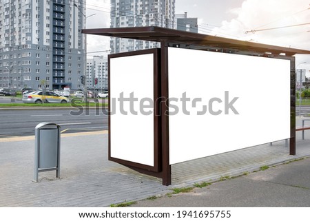 Bus stop shelter with double vertical and horizontal empty billboards on sidewalk. Concept urban commercial advertising and promotion.