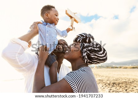 Happy African family having fun on the beach during summer vacation - Parents love and unity concept Royalty-Free Stock Photo #1941707233