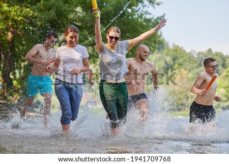 group of happy friends having fun on river