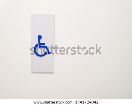 the handicap sign in front of the public bathroom.