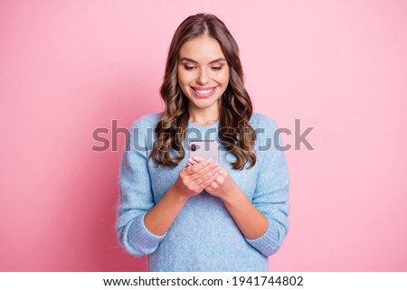 Photo of cheerful lady hold telephone look screen toothy shiny smile wear blue pullover isolated pink background