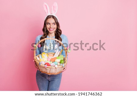 Photo of lady hold easter basket look side empty space wear rabbit ears headband blue sweater isolated pink background