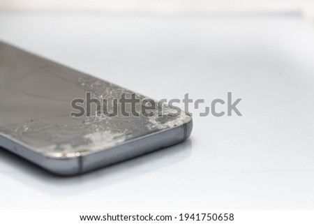 Close up of broken glass screen on a smartphone, isolated against a white background