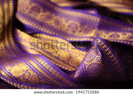 Purple violet Indian Sari border with gold paisley pattern. purple background. Royalty-Free Stock Photo #1941752686