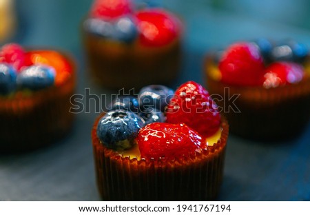 Cupcakes with berries for lunch in pastry cafe.Delicious bakery products stored in fridge.Download royalty free image of cupcakes.Download royalty free curated images collection with foods foods