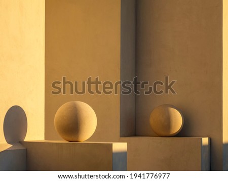 Pair of ornamental spheres, illuminated by light from setting sun, each on a ledge by exterior concrete wall of house in Alys Beach, Florida, USA