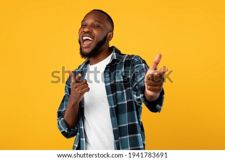 Cheerful African Guy Pointing Fingers At Camera Over Yellow Background