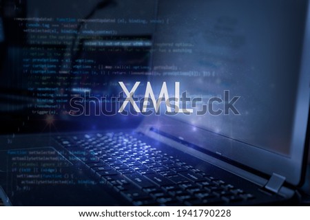 XML inscription against laptop and code background. Technology concept.