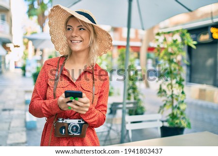 Young blonde tourist woman smiling happy using smartphone at the city.