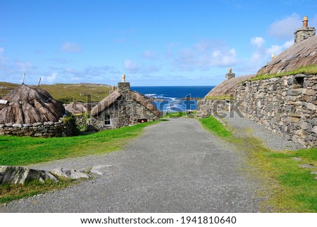 Garenin blackhouse village on the west coast of the Isle of Lewis in the Outer Hebrides of Scotland, UK on a beautiful sunny day with a view of a Garenin bay Royalty-Free Stock Photo #1941810640