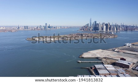 A high angle view of Governor's Island and lower Manhattan, NY on a sunny day. The East River is calm.