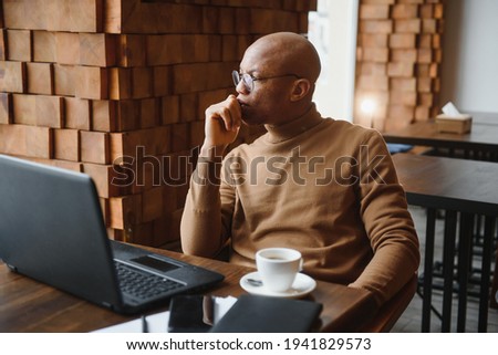 African american business man with laptop in a cafe