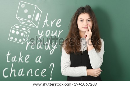 Pre-adolescent girl ponders her next step. Concept risk and chance of victory. Dice drawn in chalk. High resolution photo. Full depth of field.