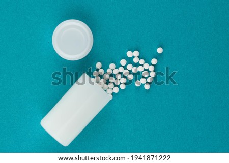 Homeopathy alternative medicine eco concept - classical homeopathy pills. Homeopathic globules on blue background. 