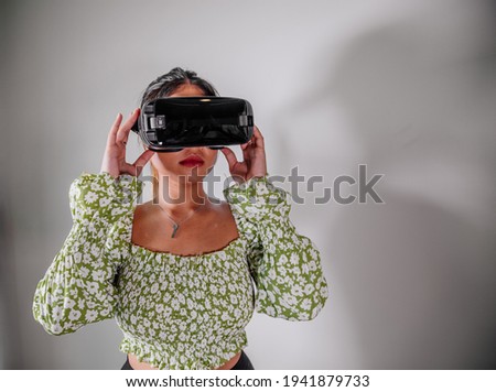 Asian Woman looking through virtual reality device at home. Augmented reality, game, future technology concept.VR