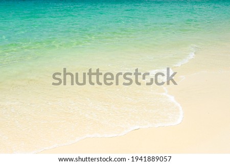 a wave of blue ocean on the sandy tropical beach on daylight Summer holiday background.
