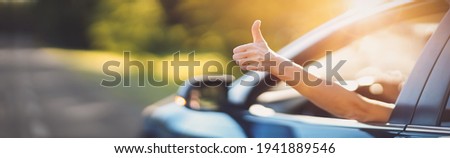 Woman inside her car gesticulate thumb up Royalty-Free Stock Photo #1941889546