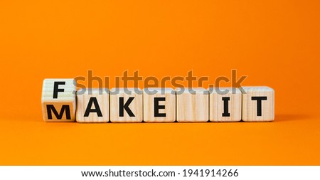 Fake it until you make it symbol. Turned a cube and changed words 'fake it' to 'make it'. Beautiful orange background. Business, and fake it till you make it concept. Copy space.