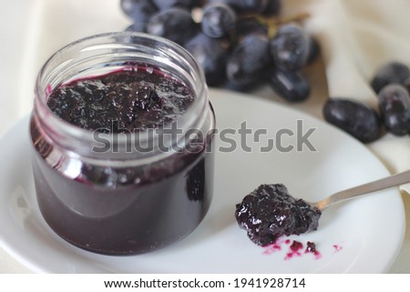 Home made Grape jam with three ingredients, seedless black grapes, sugar and lime juice. Shot on white background