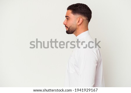 Young arab man wearing typical arab clothes isolated on white background gazing left, sideways pose. Royalty-Free Stock Photo #1941929167