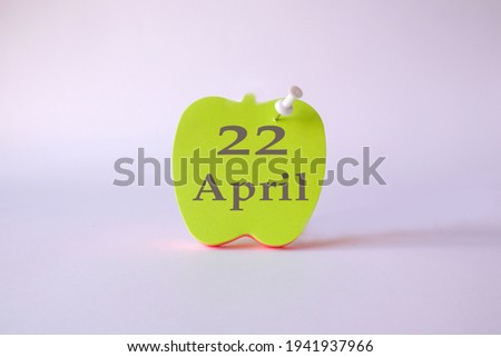 Calendar for April 22 : the name of the month of April in English, the numbers 22 on the sheets for writing in the shape of an apple, a pin, a light background
