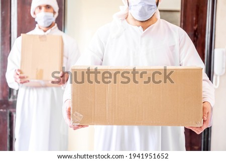 Arabic man holding box of cartoon