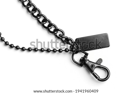 Black metal chain with carbine and tag, on a white background. Isolated object. Detail for design Royalty-Free Stock Photo #1941960409