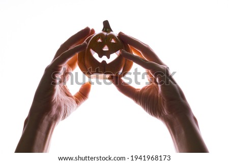 Halloween party. women's hands hold a Halloween pumpkin with a Jack's smile,