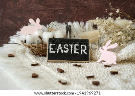 decoration for easter. inscription Easter, a basket with eggs and pink rabbits                               