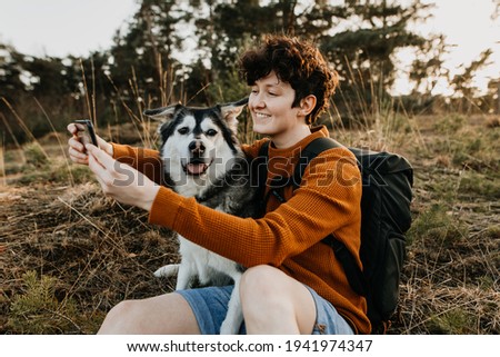 hiker taking selfie with dog 