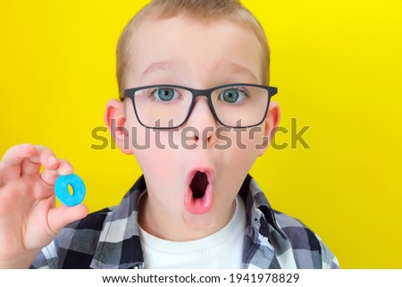 speech therapy. Toddler boy says the letter O. Classes with a speech therapist. boy on isolated yellow background Royalty-Free Stock Photo #1941978829