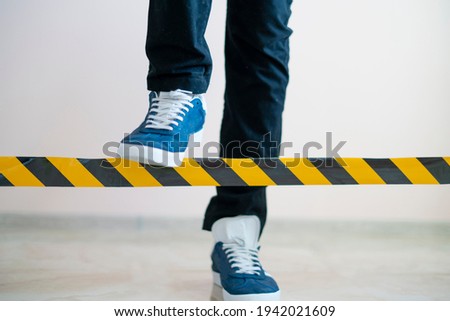 person cross the black and yellow stop line, braking the limit concept  Royalty-Free Stock Photo #1942021609