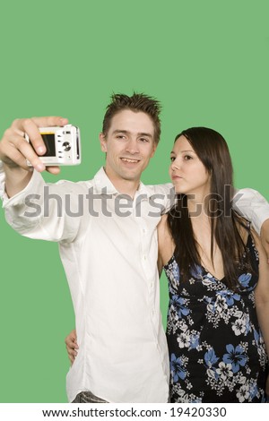 happy couple taking pictures over green screen