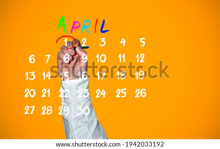 April fools day. Hand traces 1 number on the calendar close up.