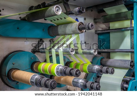 Production of duct tape.Packing tape manufacturing. Strapping Machine for Industrail Packaging Line, Modern machine for packaging line in factory, Industrial and technology concept. Royalty-Free Stock Photo #1942041148