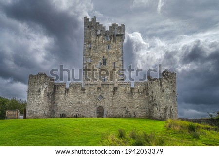 Front view on old keep from 15th century, Ross Castle located on the bank of Lough Leane with dramatic storm clouds, Ring of Kerry, Killarney, Ireland Royalty-Free Stock Photo #1942053379