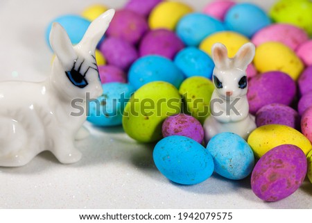 Bunnies With Speckled Candy Eggs On Snowy White