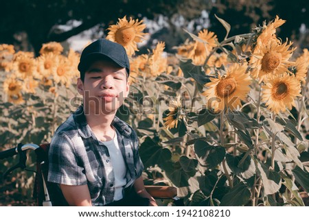 Asian special child on wheelchair in flower garden to restore mental health, Happiness with family time in holiday vacation, Education age of happy disabled kid, Travel on the nature outdoors concept.