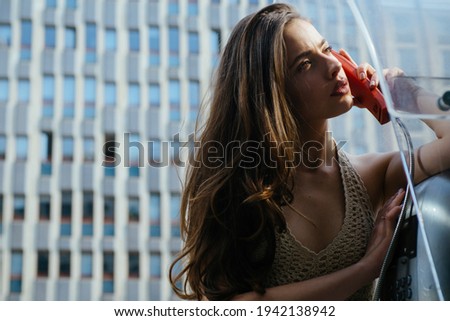 Pretty woman with payphone. Oldfashion town. Vintage concept. Communication. Oldstyled city Royalty-Free Stock Photo #1942138942