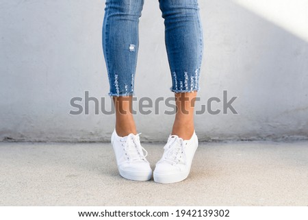 White canvas sneakers women's shoes apparel shoot Royalty-Free Stock Photo #1942139302