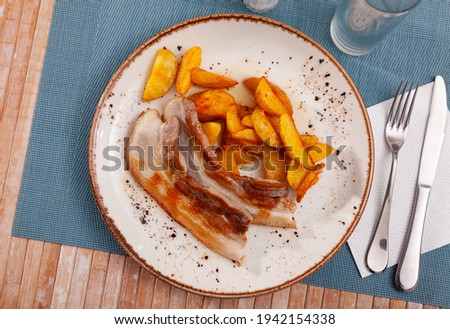 Image of fried pork bacon on a plate and French fries...