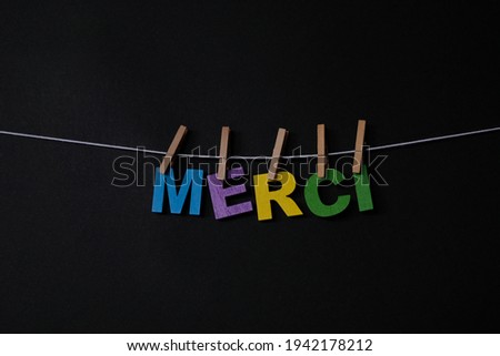 Word Merci on black background. Merci is the most common way to say thank you or thanks in French.