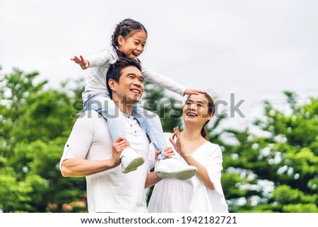Portrait of enjoy happy love asian family father and mother holding cute little asian girl child smiling playing and having fun moments good time in summer park at home Royalty-Free Stock Photo #1942182721