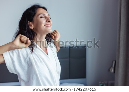 Beautiful woman waking up on her bed at bedroom Young Female stretching and smiling overjoyed Beauty Lady wake up meet good weekend early morning Young lady feel optimistic at home with smile face Royalty-Free Stock Photo #1942207615