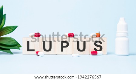 LUPUS word made with building blocks. A row of wooden cubes with a word written in black font is located on white background