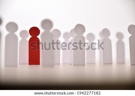Social discrimination concept with many little paper men and a different one on wooden base front view Royalty-Free Stock Photo #1942277182