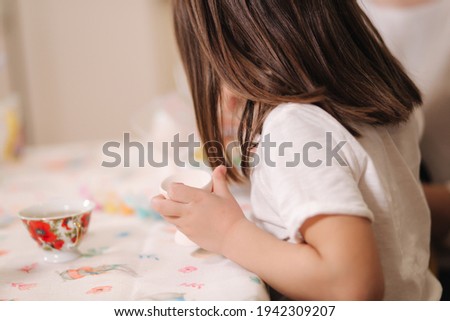 Close up of little girl hold easter egg in hand and make a picture