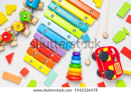 Children's toys made of natural wood on white background. Multi-colored pyramid, train, constructor, xylophone in rainbow colors. Eco friendly toy, plastic free. Toy for babies and toddlers Flat lay Royalty-Free Stock Photo #1942326478