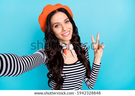 Photo of young attractive girl happy positive smile make selfie show peace cool v-sign isolated over blue color background