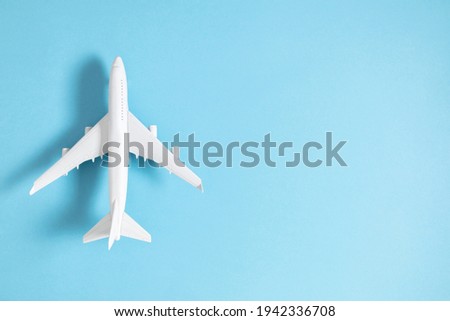 Airplane model. White plane on pastel blue background. Travel vacation concept. Summer background. Flat lay, top view, copy space